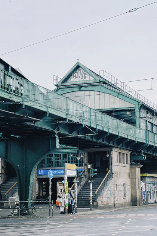 a large green bridge next to the top of a building