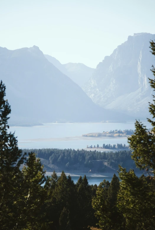 there is a view of trees, mountains, and a lake