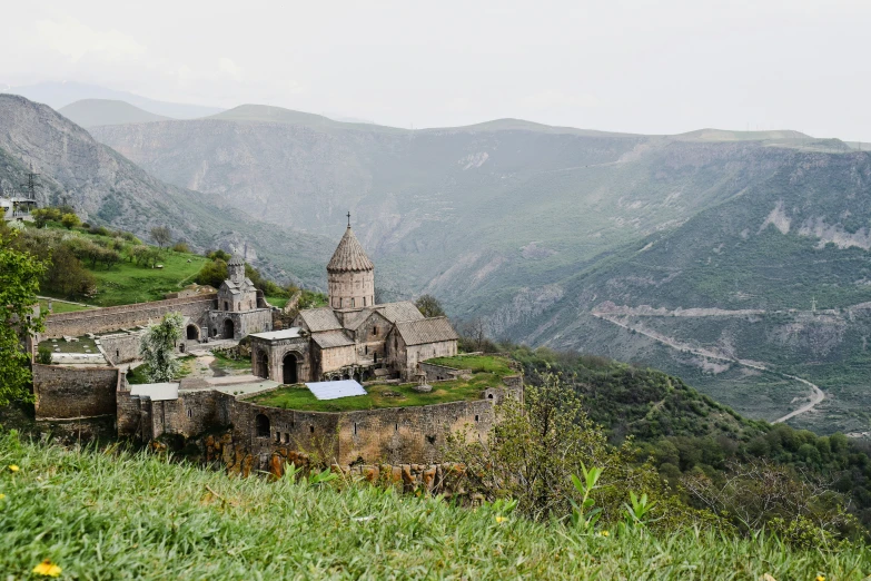 a church nestled between two mountains on top of a hill