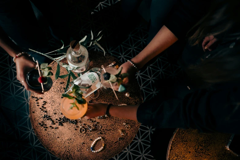 people standing around a tray with several champagne glasses and bottles