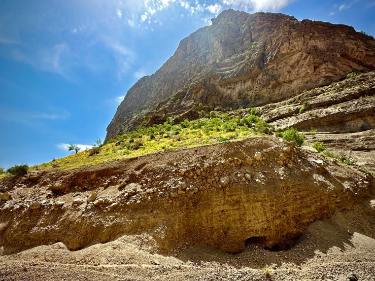 a very tall cliff with some grass on the side of it