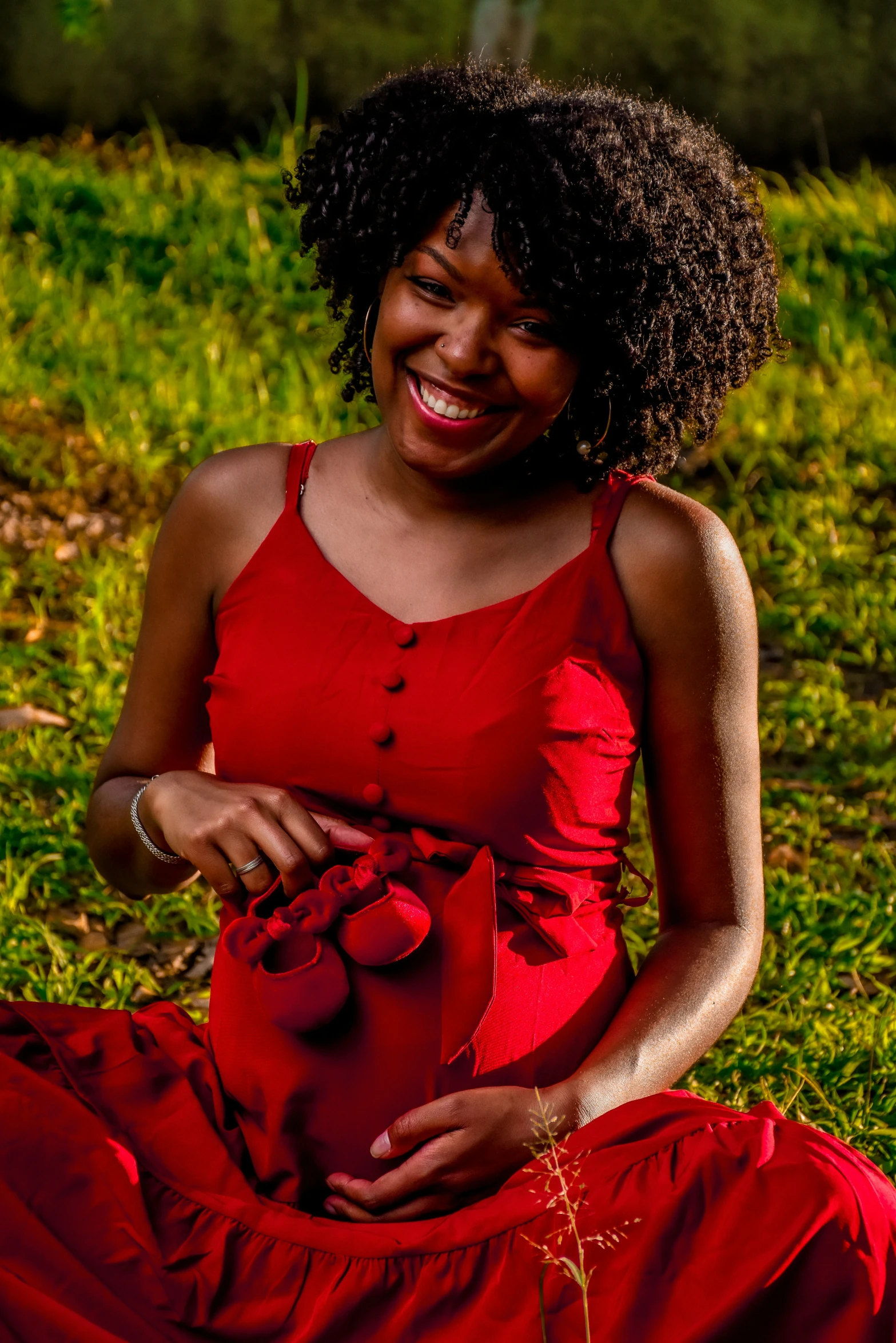 a beautiful young woman sitting on the ground with an orange stuffed animal