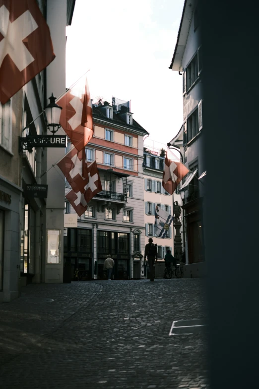 red flags flying from a building on a street