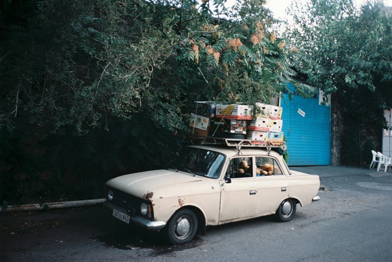 a brown and white car with luggage on top