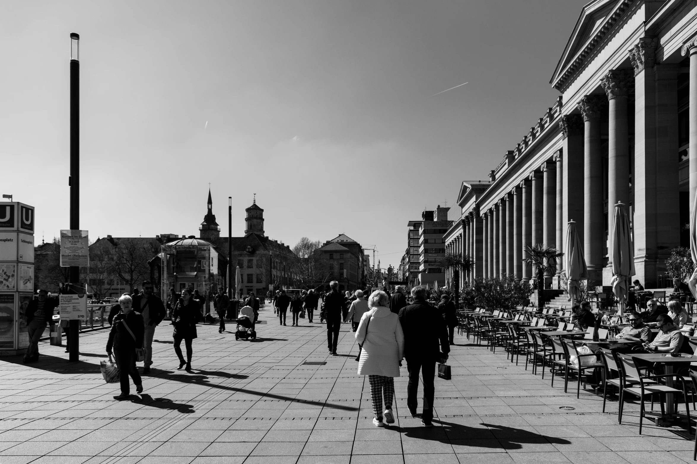 black and white po of people walking in front of buildings