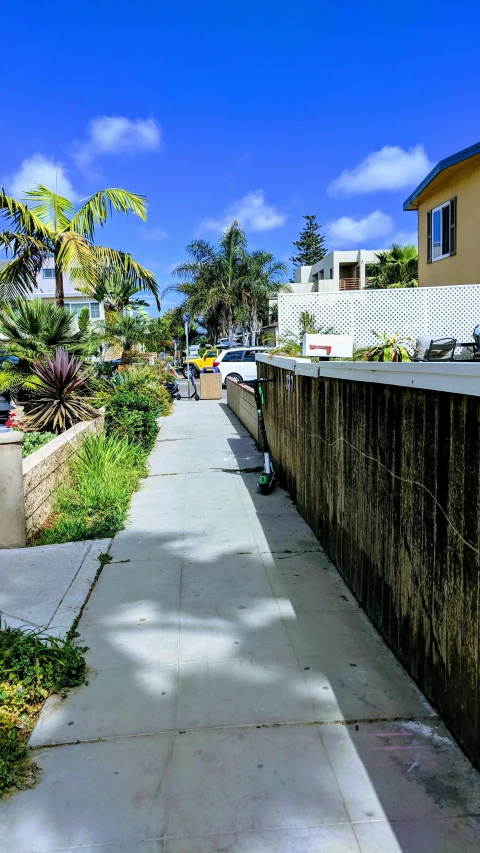 a sidewalk leading down to a parking lot with some cars