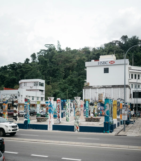 a building on the corner of the road with lots of signs hanging off the sides