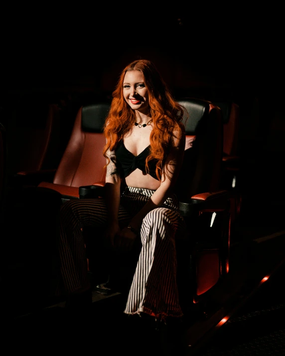 a beautiful red headed woman sitting in a chair