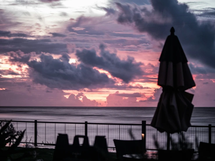 clouds hover over the ocean as the sun sets