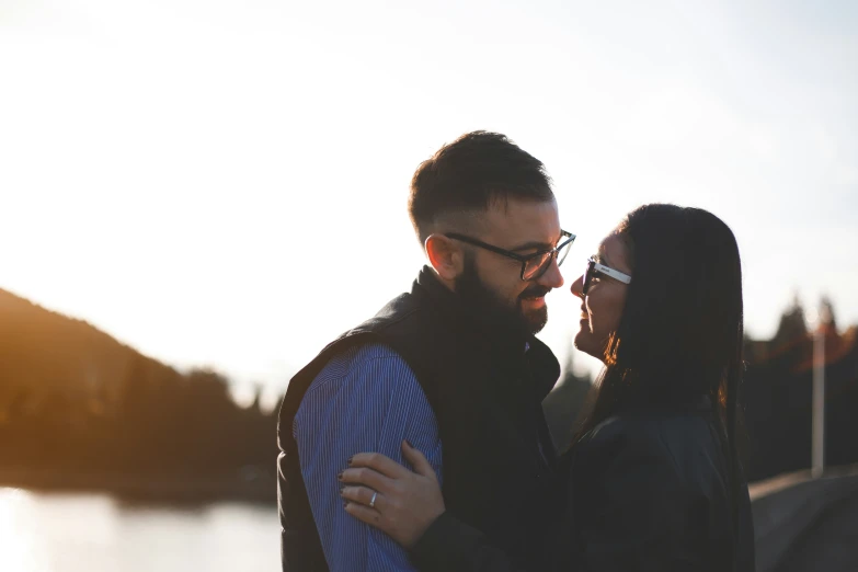 man and woman in love standing together with water in the background