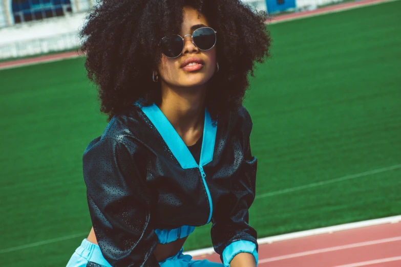 a black woman wearing sunglasses and sitting on a bench