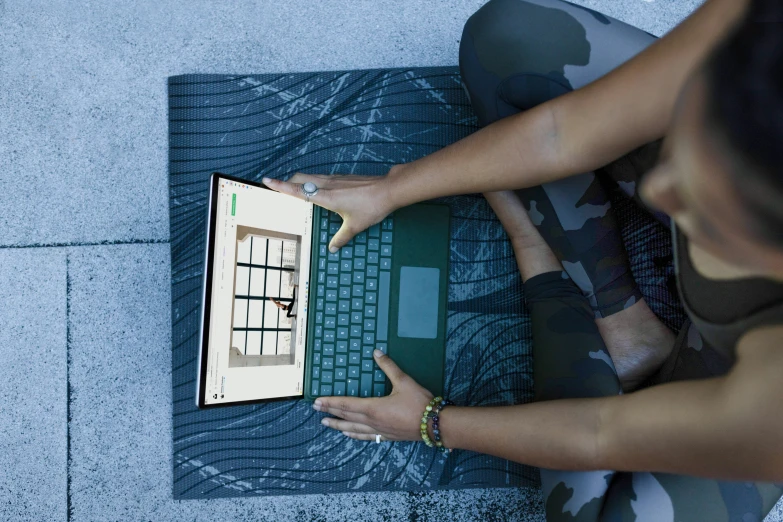 people using laptop computer on carpeted area outdoors