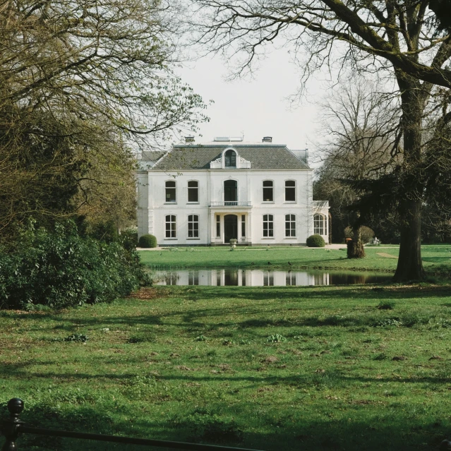 a large white house with several windows that are overlooking a body of water