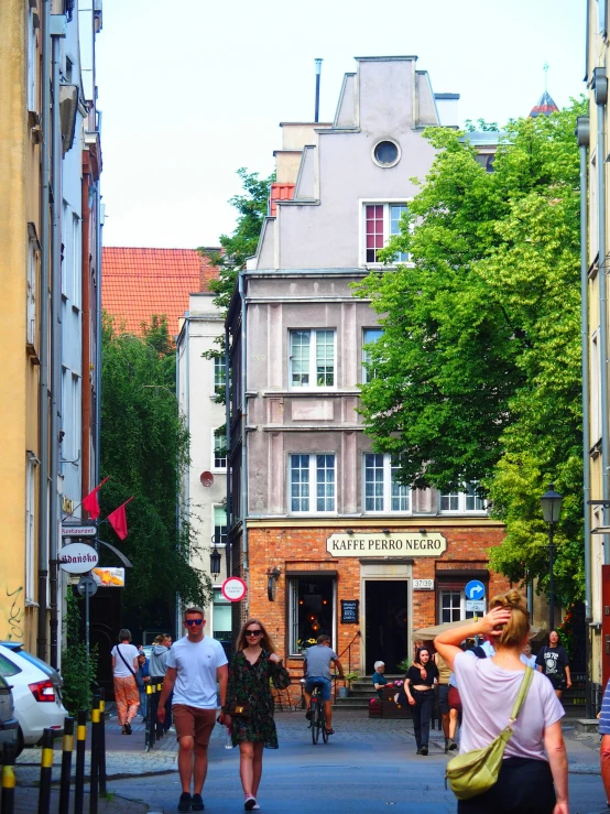 several people walking on the sidewalk in a city
