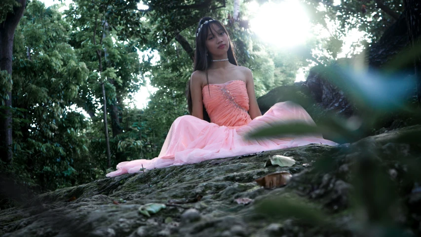 a woman sitting on a rock in the woods