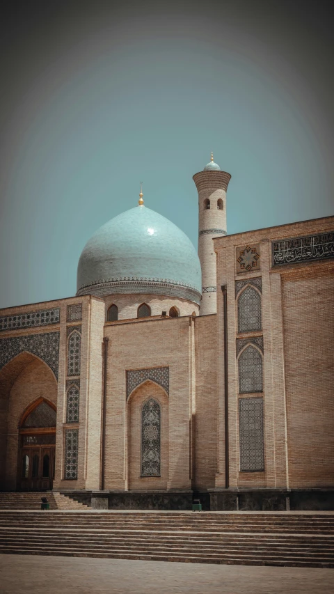 a brown building with stairs leading to a tower and a dome