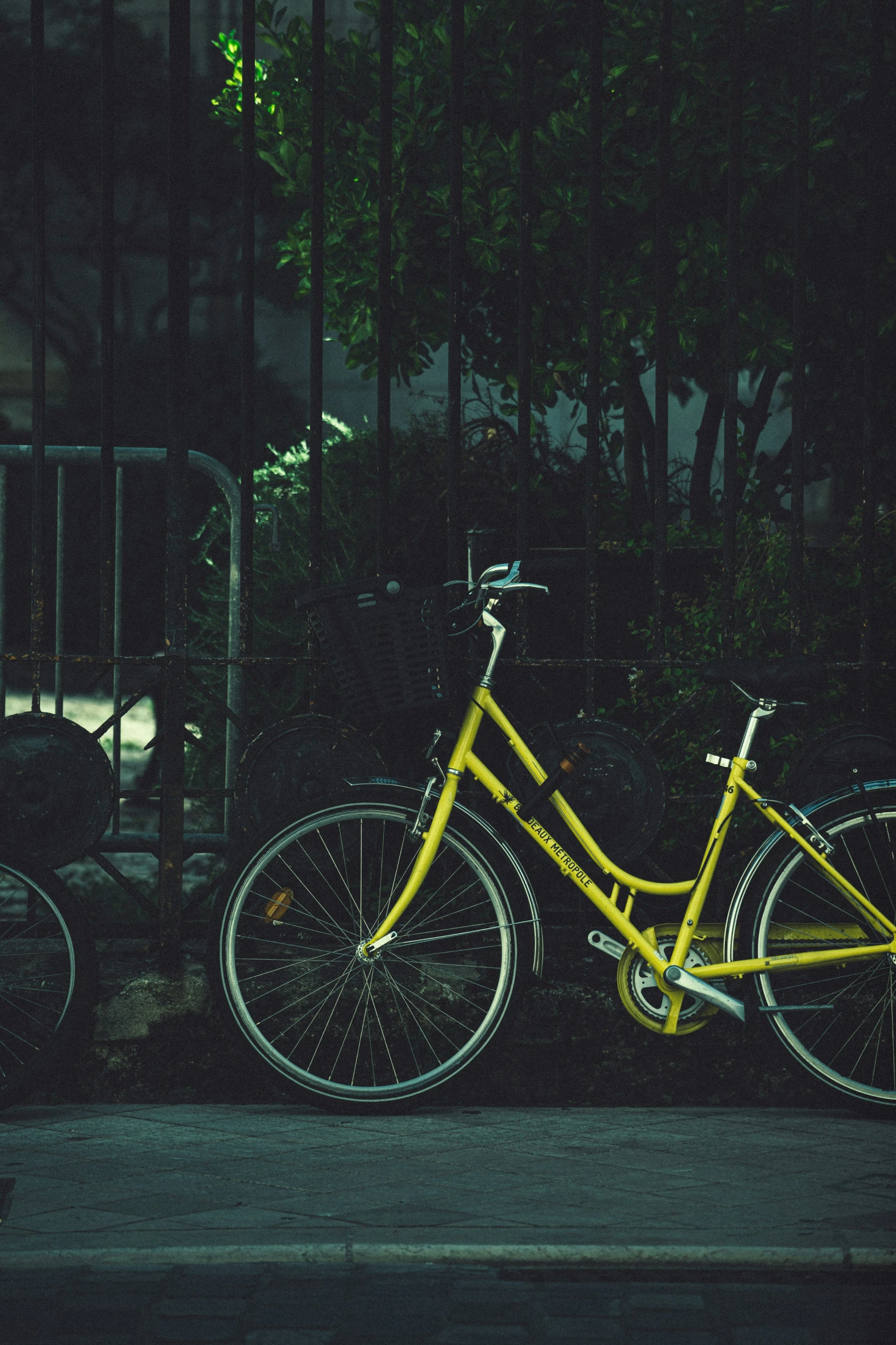 a bike parked next to a metal fence