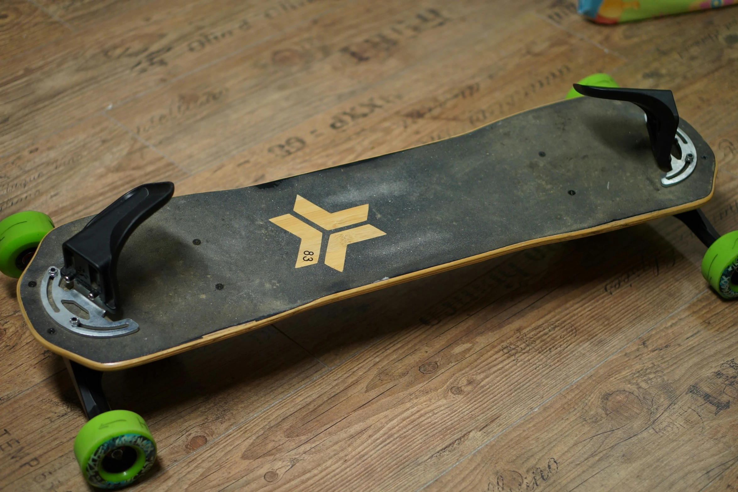 a skateboard with wheels is on a wooden floor