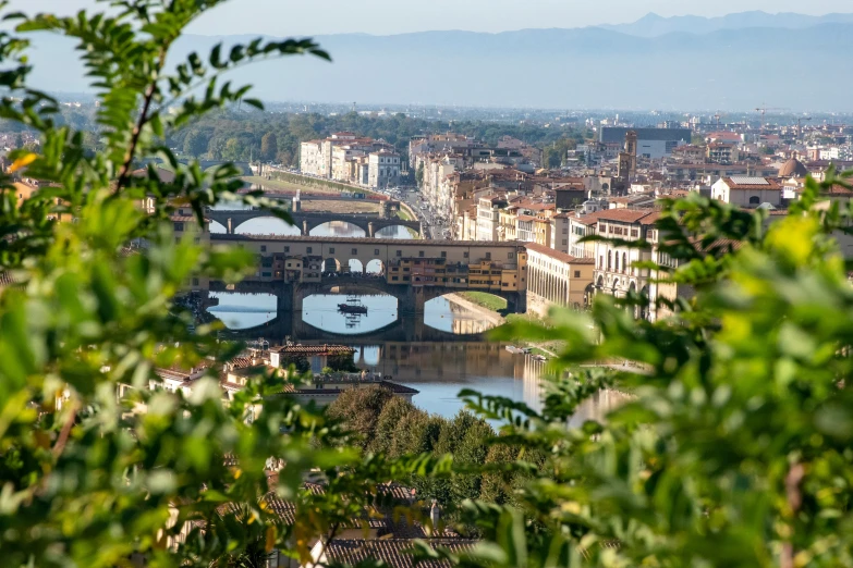 a bridge crosses over the city's river, with many buildings