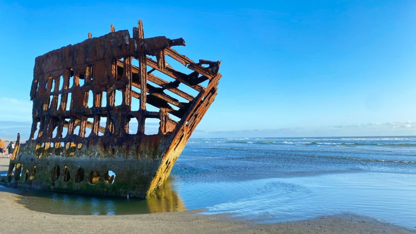 a very old structure sitting in the sand on the beach