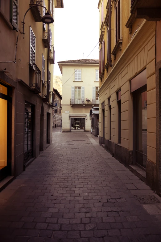 a narrow street with buildings around it in an area that is somewhat empty