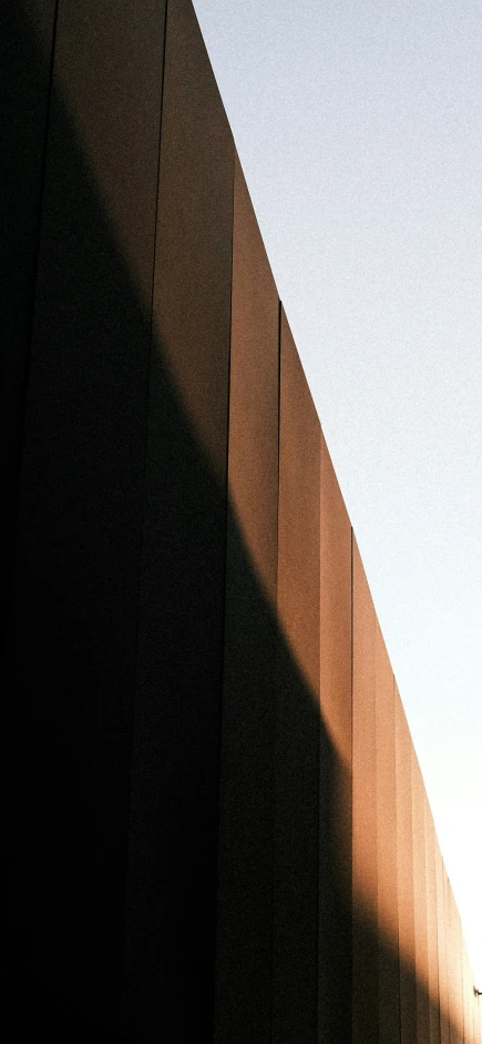 a tall orange building with the sky in the background