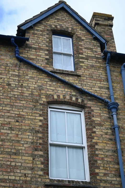 a red brick house with two skylights attached to it's side