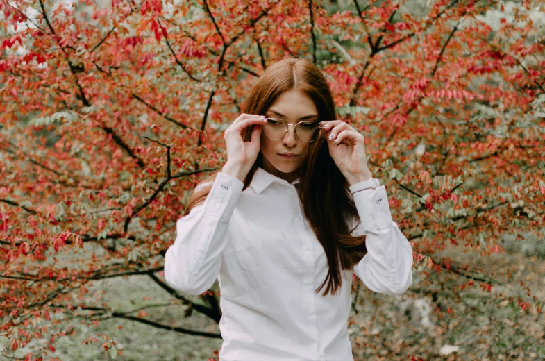 a woman is standing in front of a tree