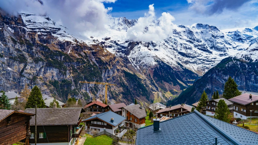 a village with a snowy mountain view in the background