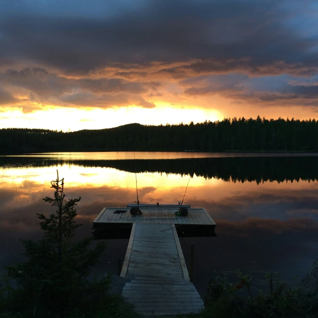 a dock with some fishing rods on it near water