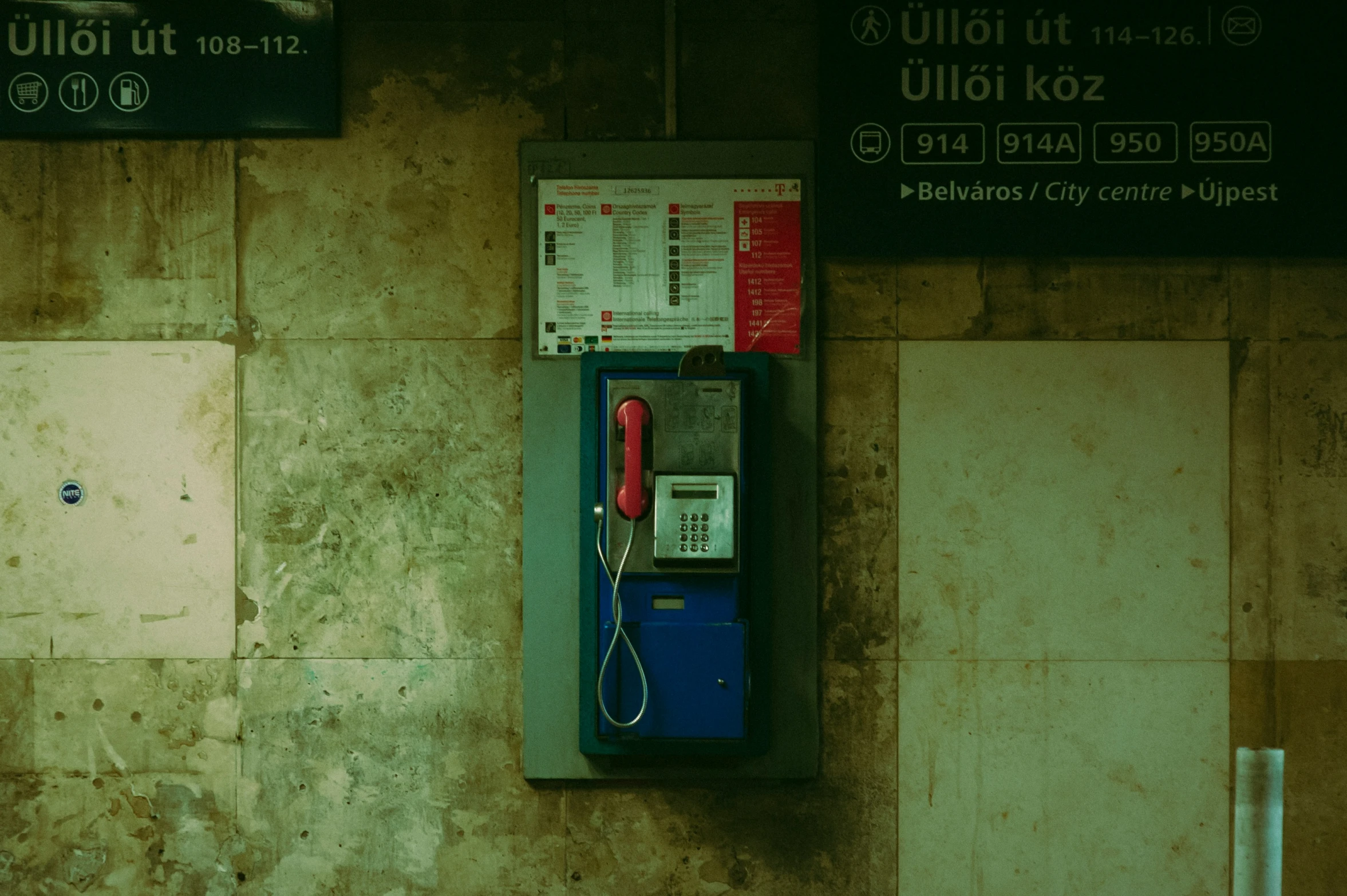 an old style pay phone is next to a sign