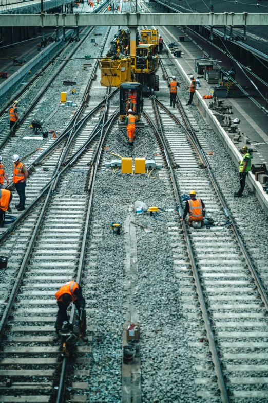 workers on a railway track next to the tracks and work trucks