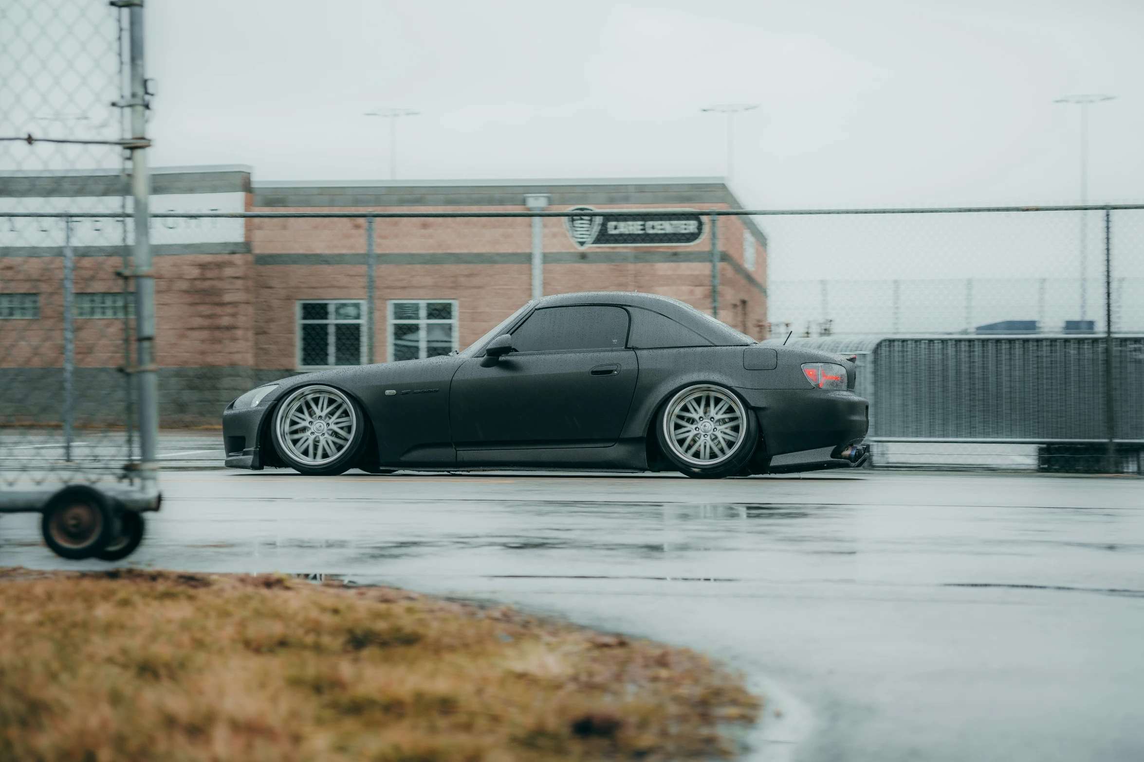 a car is parked on the street in the rain