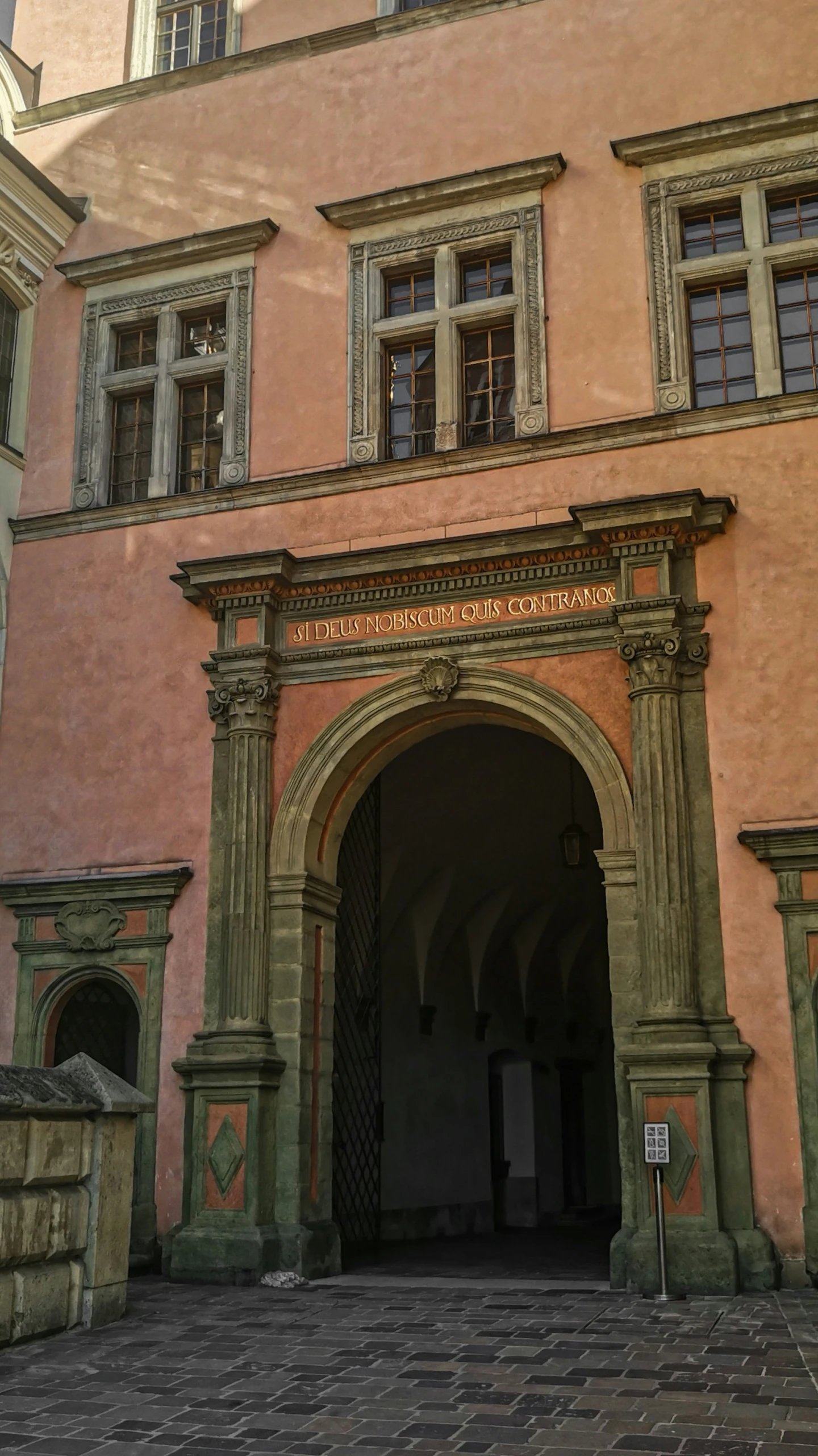 a pink building has a large archway