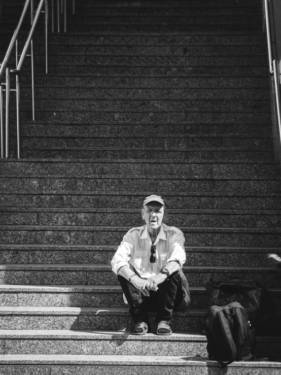 a man sitting on some steps with luggage