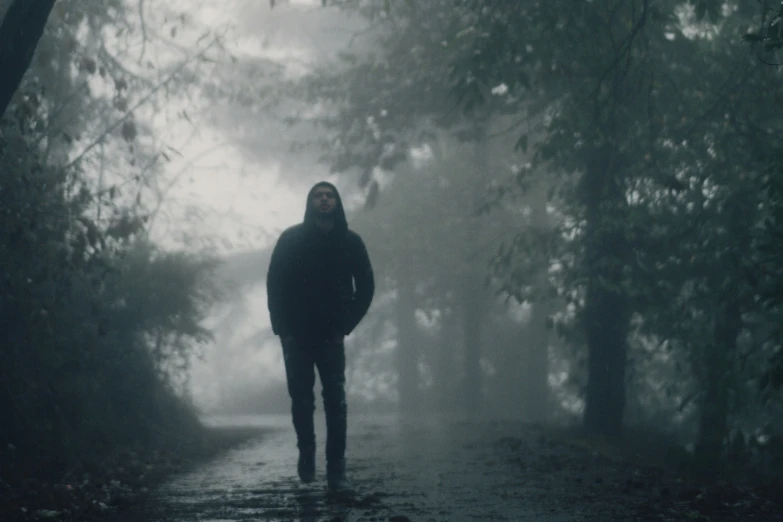 person walking away in the rain on a path