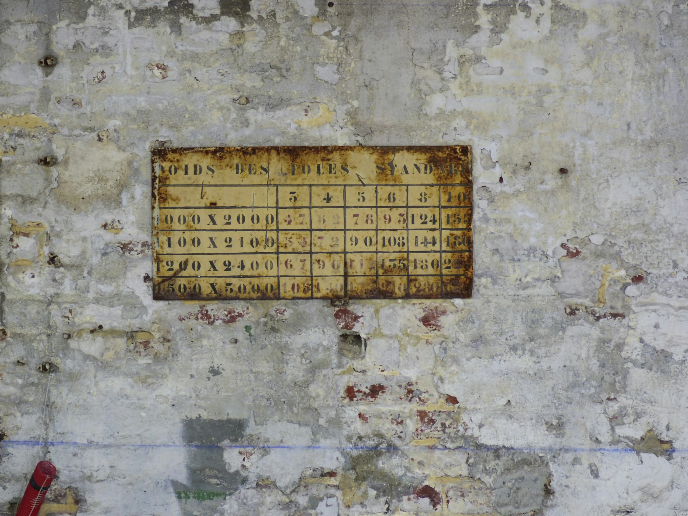 an old wall with a large, broken up sign on it