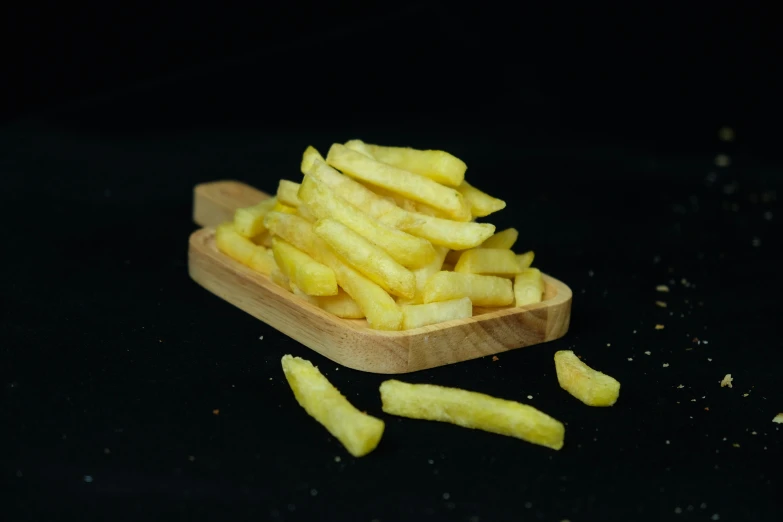 cut into small pieces of fries on a wooden tray