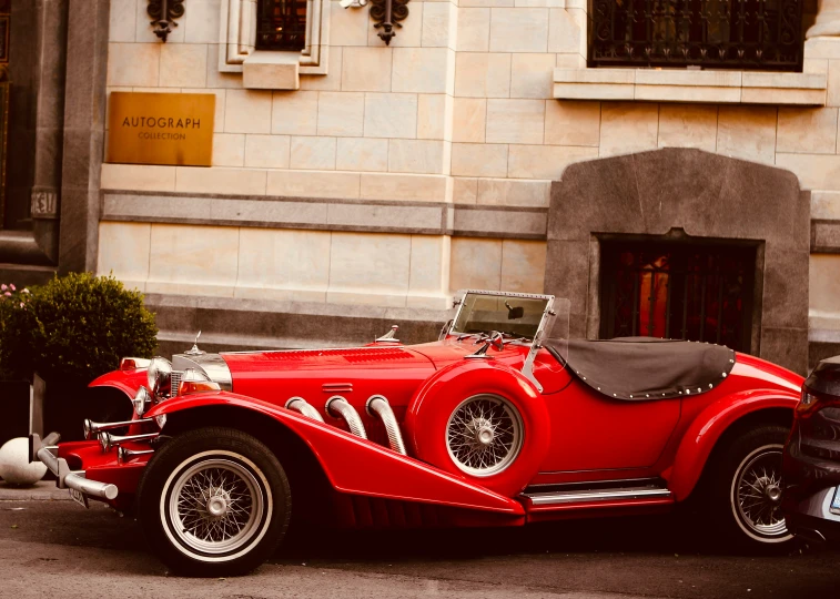 a red sports car sitting in front of a building