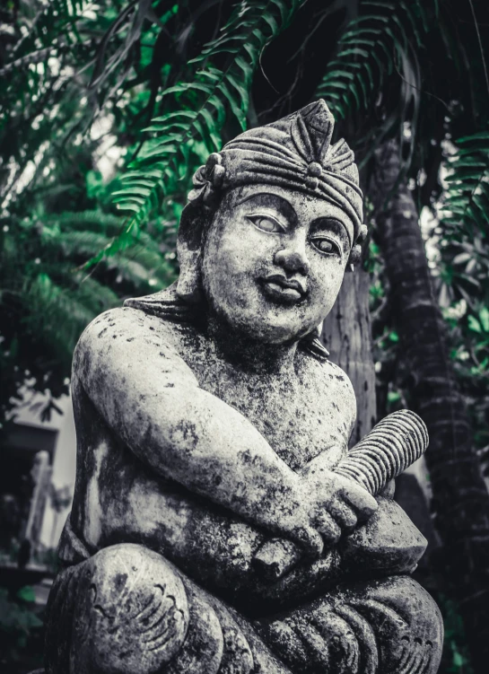 black and white po of a statue sitting in the middle of trees