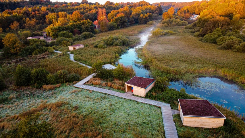 an aerial view shows two small structures near a stream