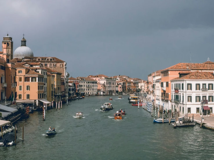 some boats are going down the water between buildings