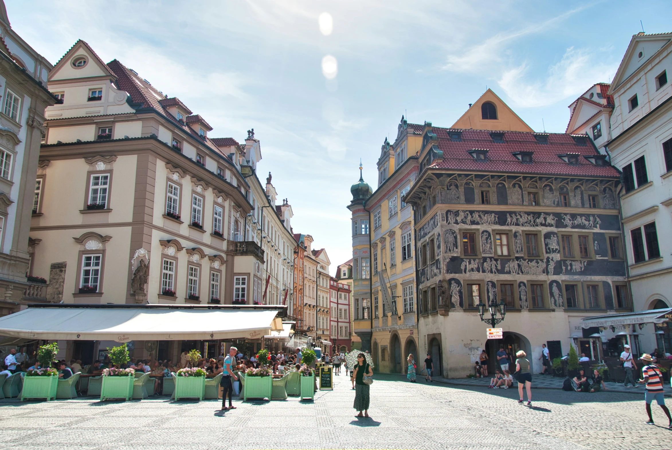 a town square surrounded by old buildings and a green fence