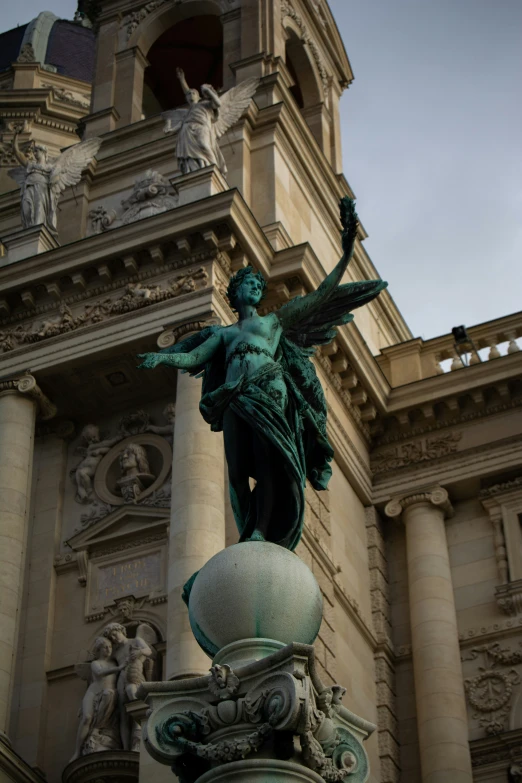 an ornate statue with a clock tower behind it