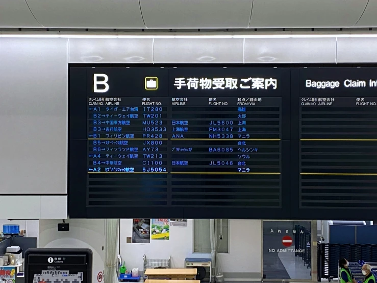 an electronic airport sign above a conveyor belt