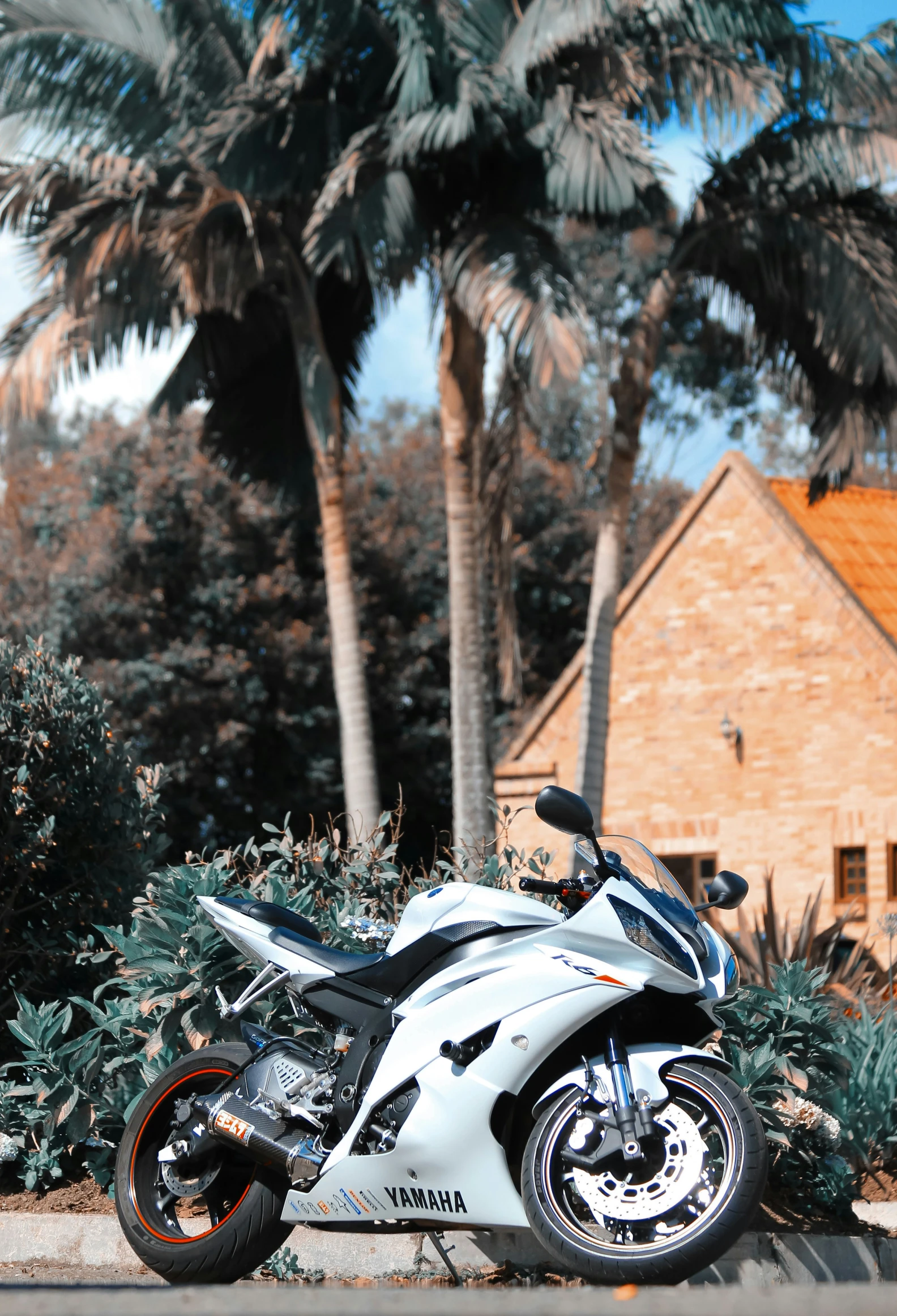 the motorcycle is parked on the curb outside of the house