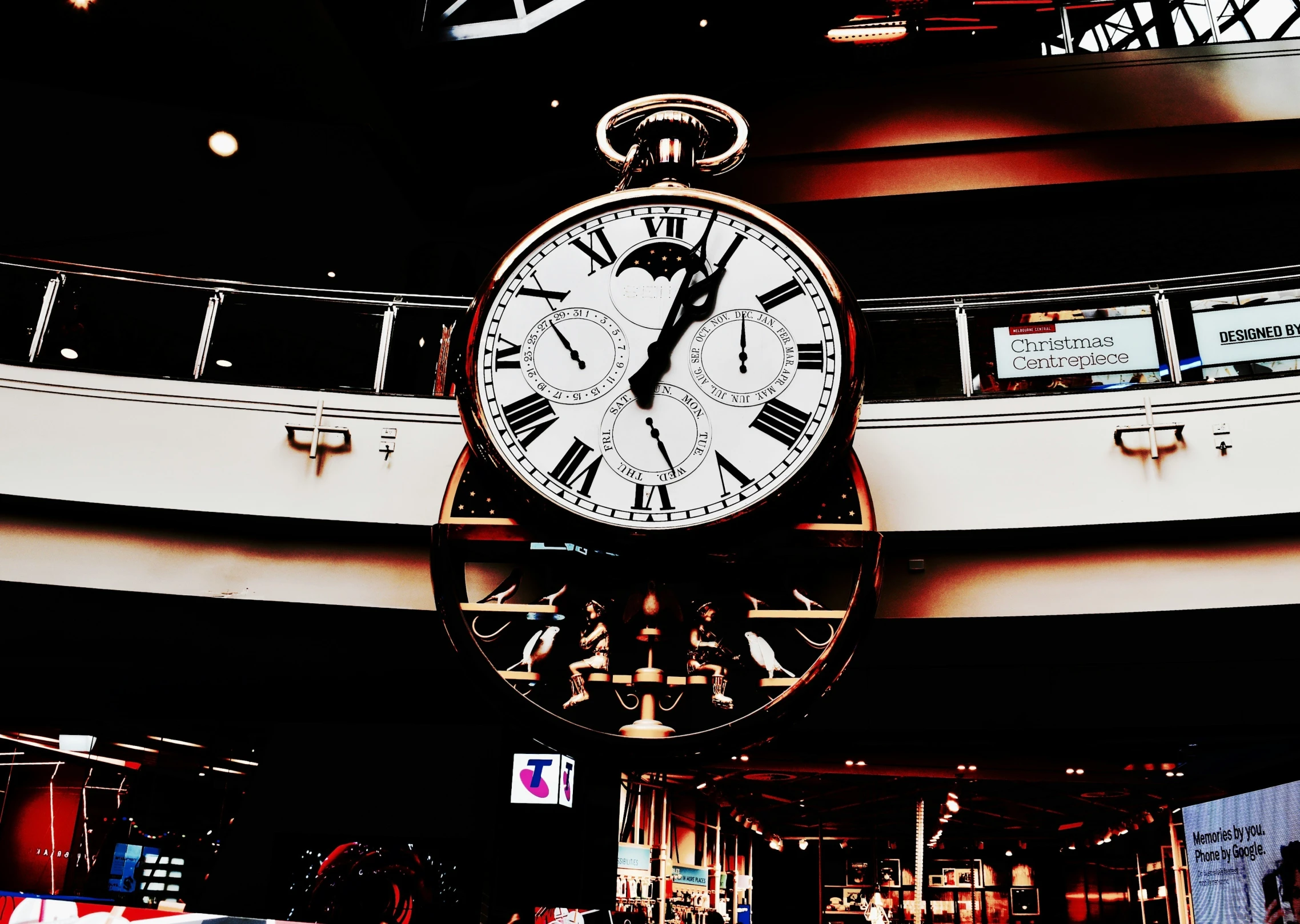 the clock is hanging from the ceiling of a building