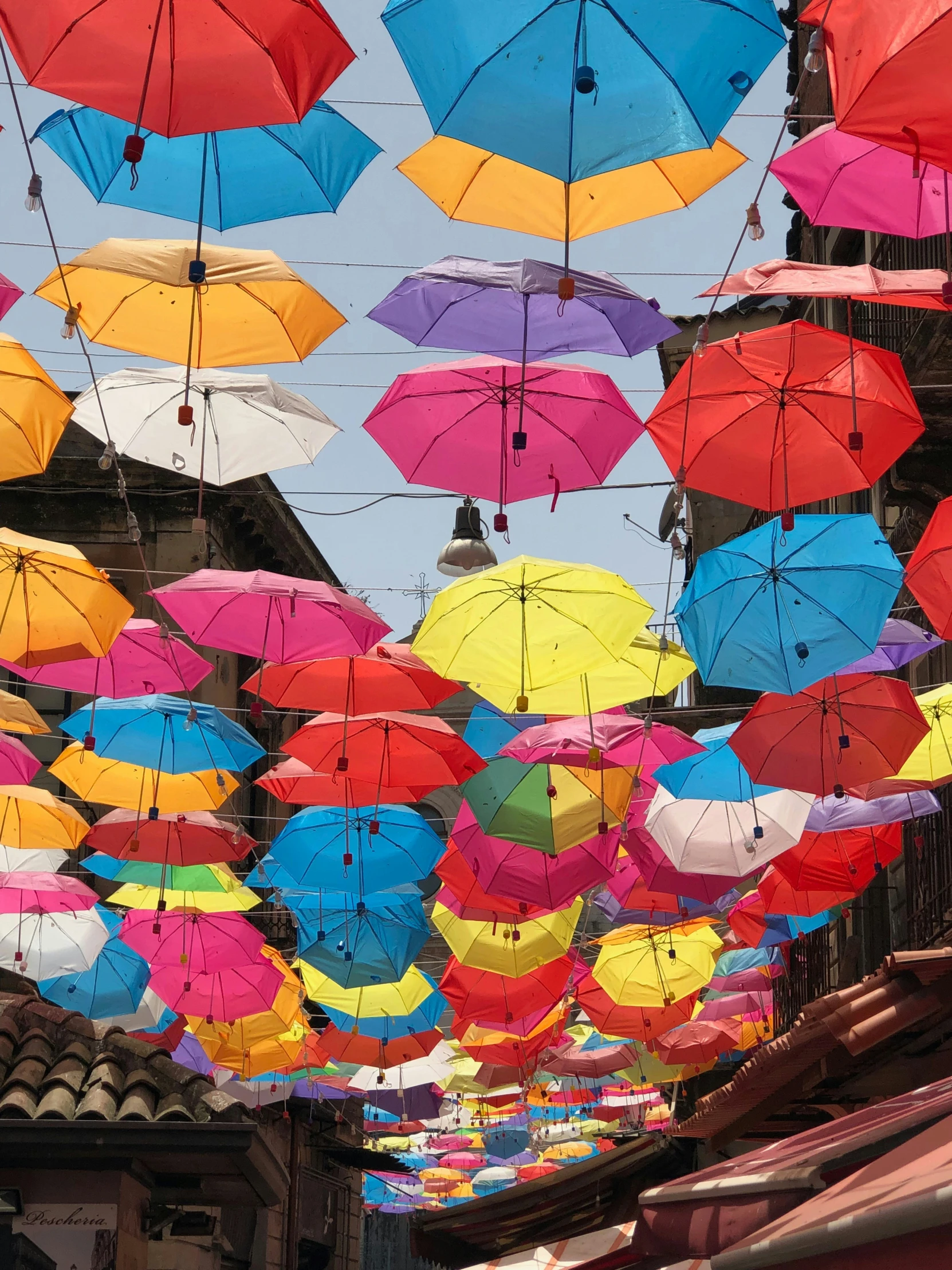 there are many colorful umbrellas flying above the streets