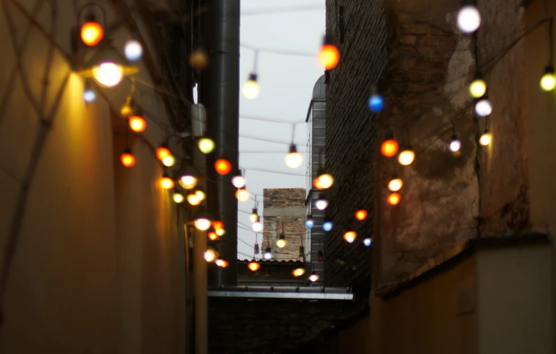 lights hang down a narrow alley way from buildings