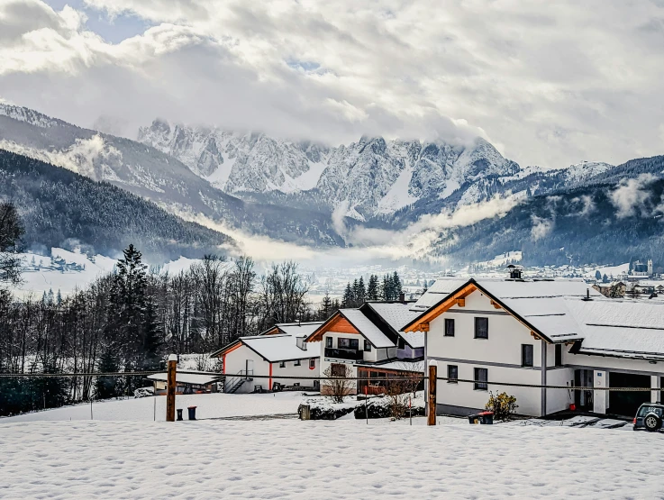 some snow mountains are behind some houses